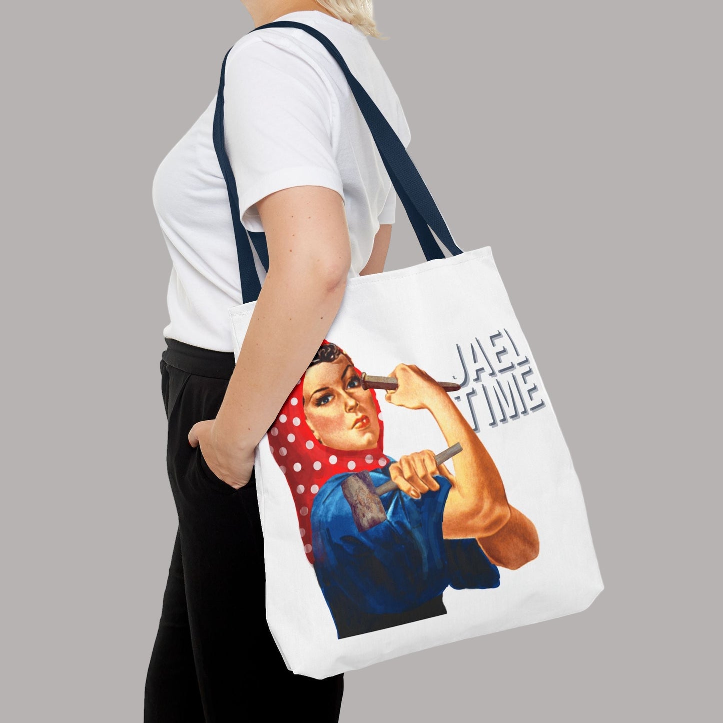 Tote bag with vintage graphic design of a woman holding a hammer, and tent spike, text 'Jael Time' on a white background. Insoired by Biblical account of Yael.